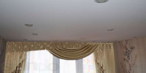 Тканевые натяжные потолки Тканевые натяжные потолки представляет собой полотно, изготовленное по технологии плетения нейлоновых нитей в сетку и последующую ее пропитку специальным раствором из полиуретана. Тканевые полотна позиционируются производителями как материалы для драпировки потолков и стен и относятся к классу дорогостоящих текстильных продуктов.Устойчивость к перепадам температур, позволяет устанавливать такие потолки даже в неотапливаемом помещении, что актуально, если речь идет об отделочных работах в загородных домах сезонного проживания. Температурный диапазон эксплуатации тканевых потолков колеблется от -40 до +80 С.